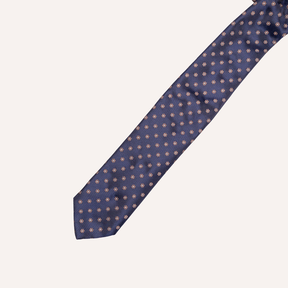 A navy blue necktie with a small taupe flower dot pattern