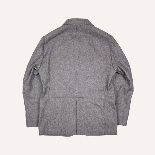 A gray textured wool blazer shown from the back, laid flat against a light cream background.