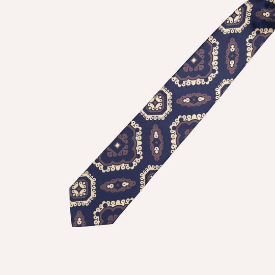 A navy blue necktie with a detailed paisley pattern in brown and cream, shown diagonally on a light off-white background.