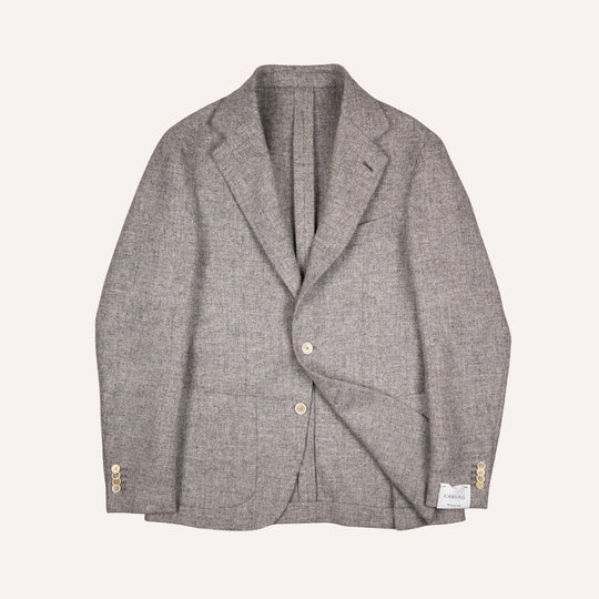 A light gray textured tweed blazer with notched lapels, two front buttons, and cream tone button accents on the cuffs, laid flat against a light cream background.