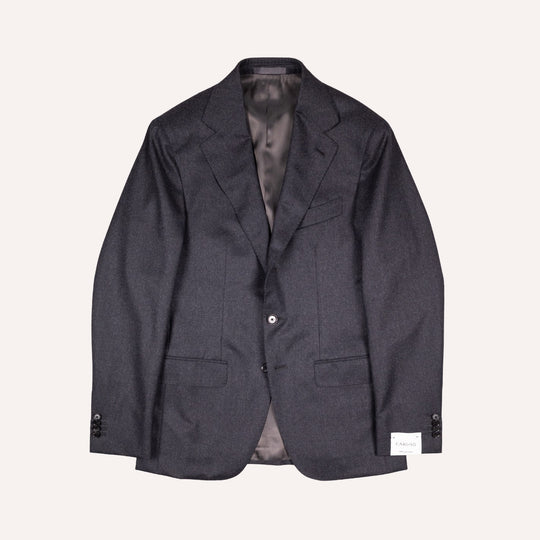 A dark charcoal gray textured wool blazer jacket with a single button closure, laid flat against a light cream background.