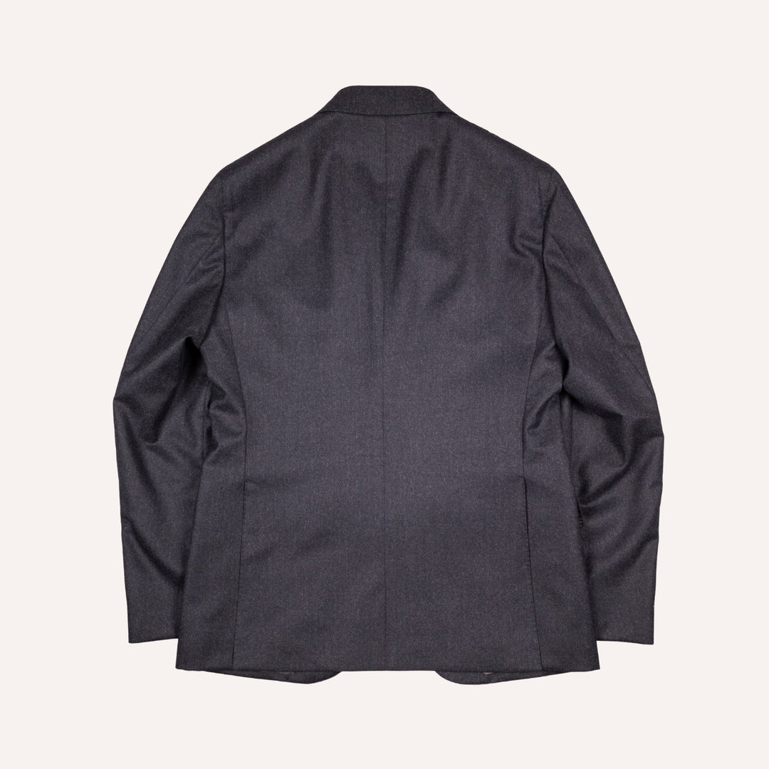 A dark charcoal gray blazer shown from the back, laid flat against a light cream background.