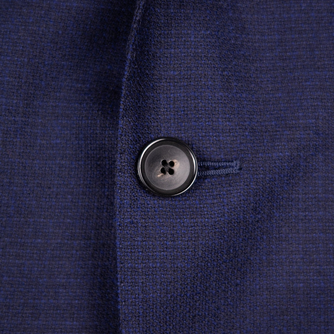 Close-up of a dark navy blue textured knit fabric with a single black button on the front.