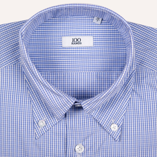 Close-up of a blue and white micro-check patterned button-down shirt collar with a visible '100 HANDS' brand label.