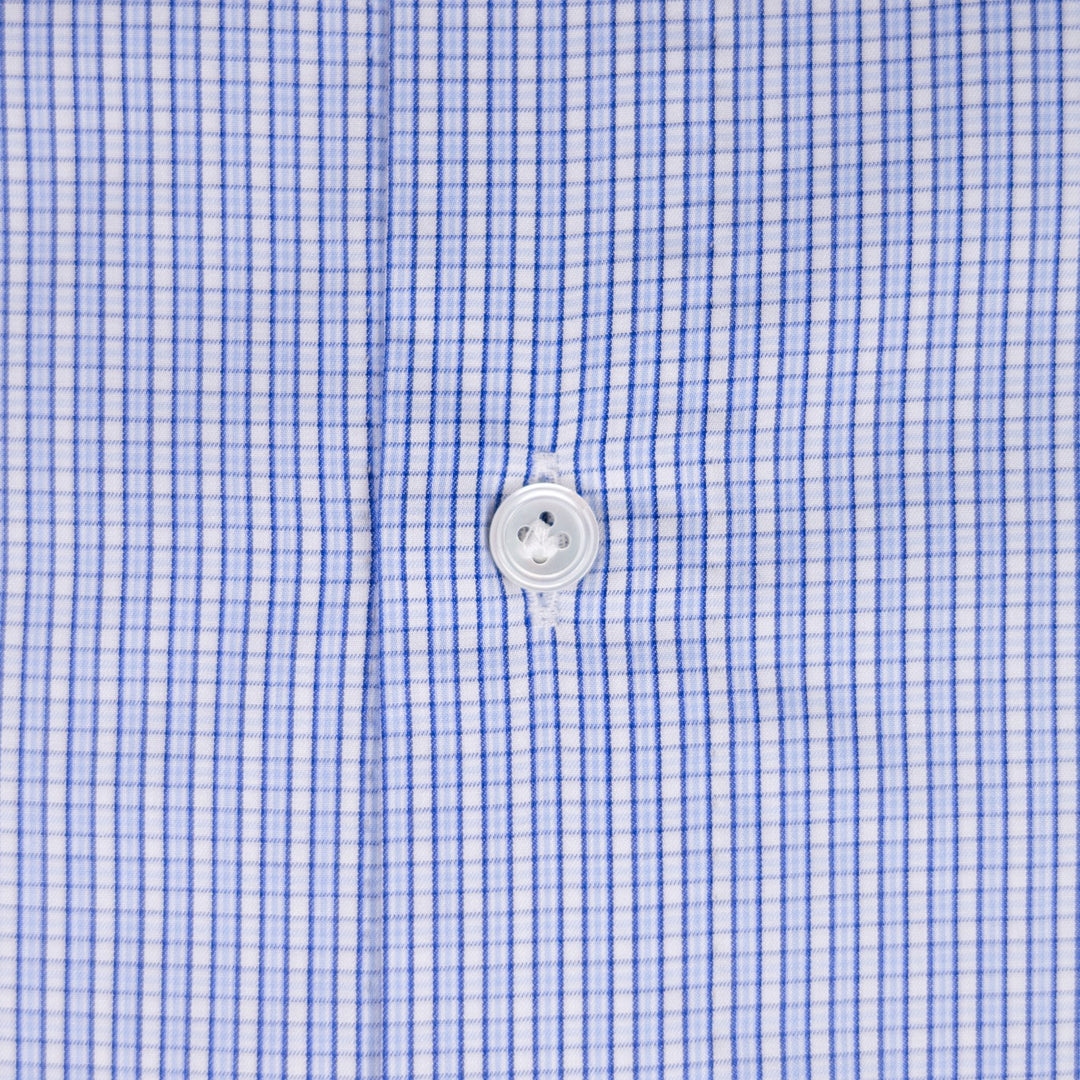 Close-up of a blue and white gingham checkered shirt fabric with a white button at the center.