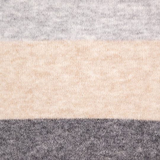 A close-up of a soft knit fabric with horizontal stripes in light gray, warm beige, and dark charcoal gray.