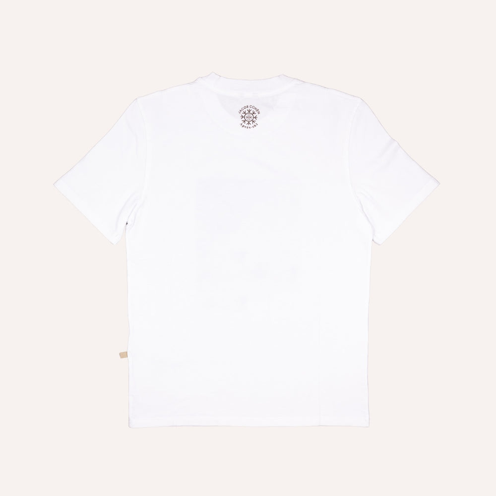 White short-sleeve crewneck t-shirt shown from the back, featuring a small circular graphic print near the inner neckline and a small beige tag near the bottom left hem, set against a solid off-white background.