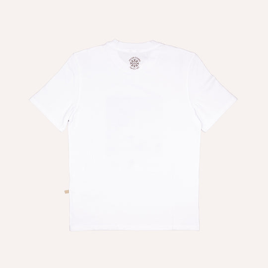 White short-sleeve crewneck t-shirt shown from the back, featuring a small circular graphic print near the inner neckline and a small beige tag near the bottom left hem, set against a solid off-white background.