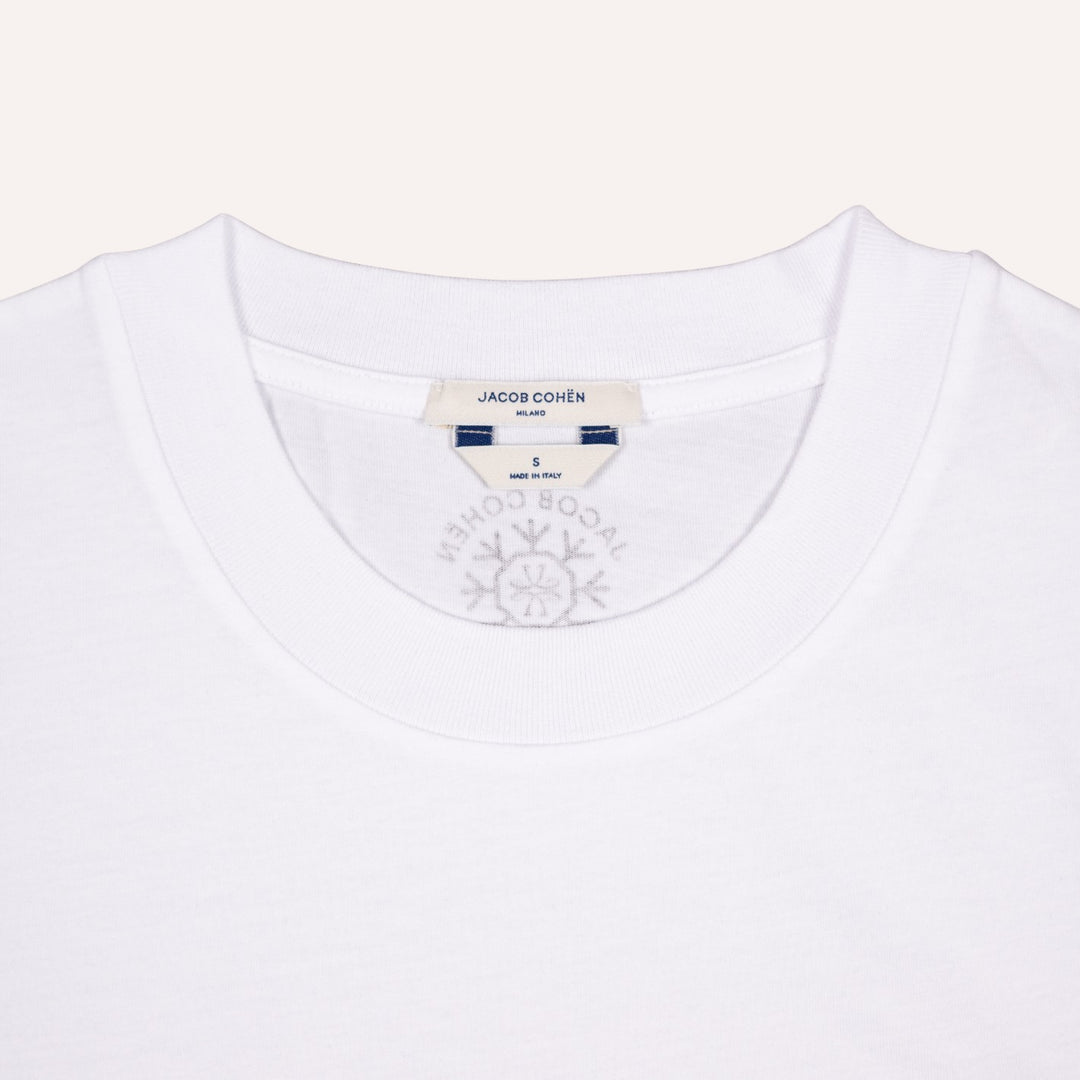 Close-up of a white crewneck t-shirt by Jacob Cohen Milano, showing the inner neck label and a faint gray brand logo printed inside the collar.