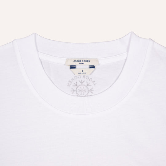 Close-up of a white crewneck t-shirt by Jacob Cohen Milano, showing the inner neck label and a faint gray brand logo printed inside the collar.