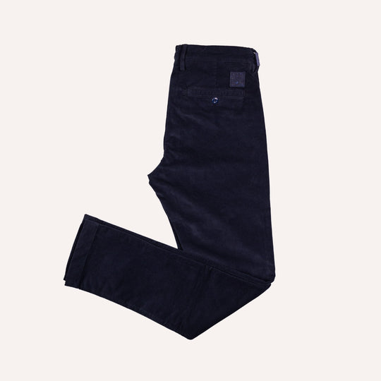 A pair of dark navy twill pants laid flat on a light cream background.