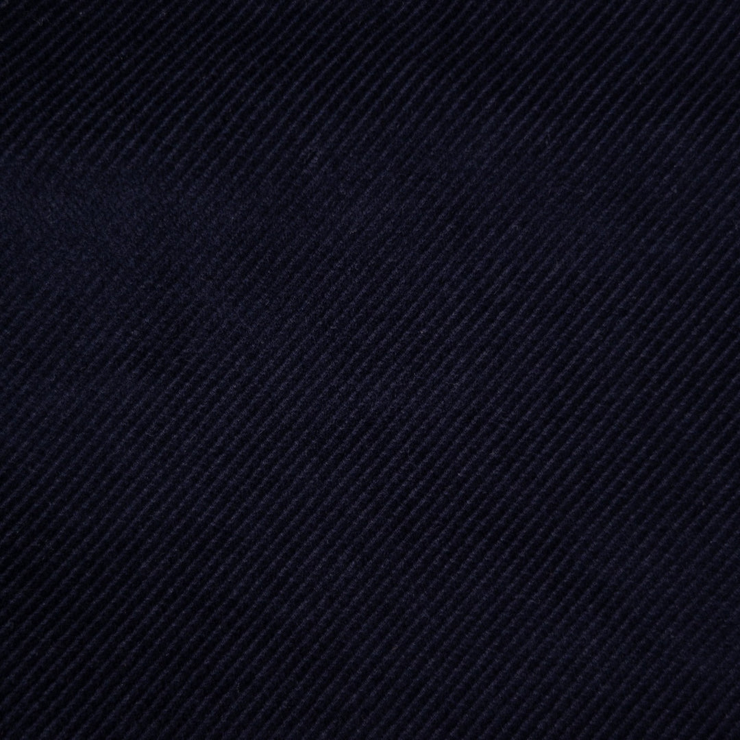 A close-up of dark navy blue textured fabric with a diagonal twill weave pattern.