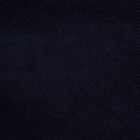 A close-up of dark navy blue textured fabric with a diagonal twill weave pattern.