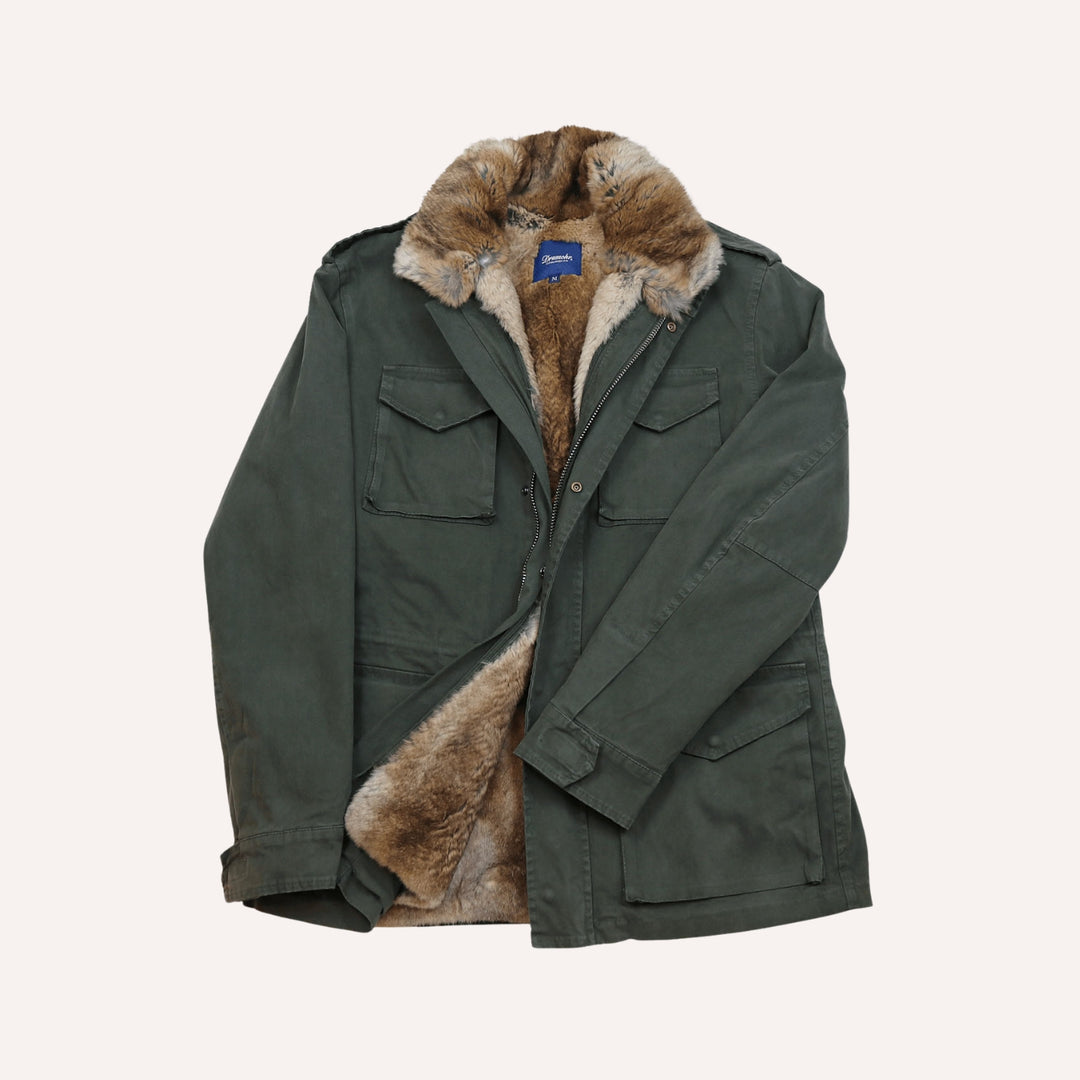 An olive green military-style parka jacket with a thick brown and beige rabbit fur collar lining, displayed flat against a light cream background.